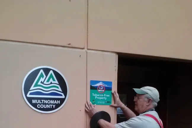 Smokefree sign being installed outside on county property