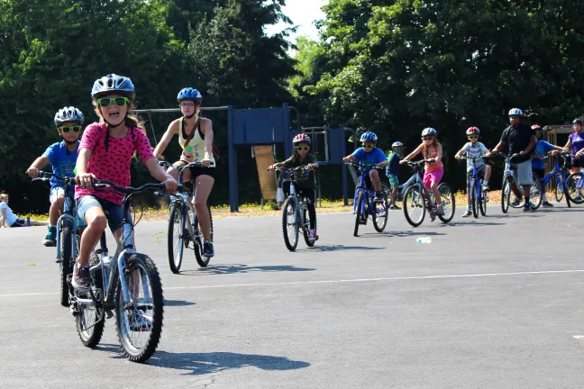 Children ride their bikes at the Sitton Elementary School-based SUN Summer Camp .