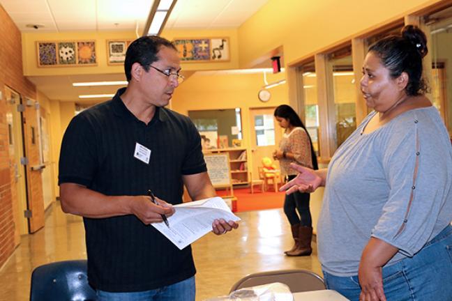 Adriana Larraga and community health specialist Marcos Reyes (right) at a Multnomah County-sponsored flu clinic.