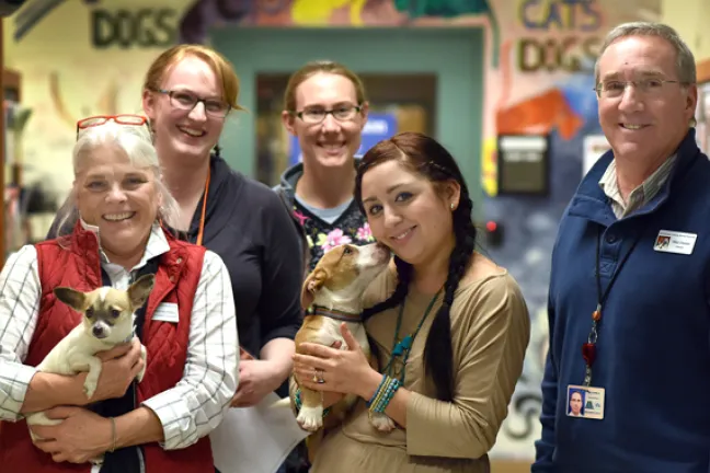 Multnomah County Animal Services employees and volunteers pose with adoptable pets  