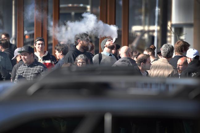 People who use e-cigarettes, own and work at vape shops, gather outside the Multnomah Building before Thursday's board meeting.