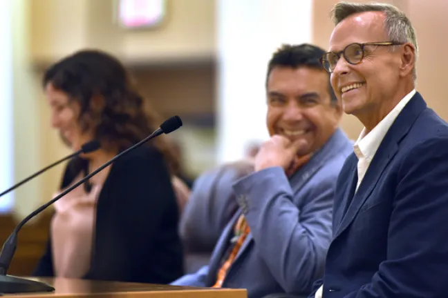 John Halseth addresses the board on Thursday as his husband Robin Castro (center) smiles on