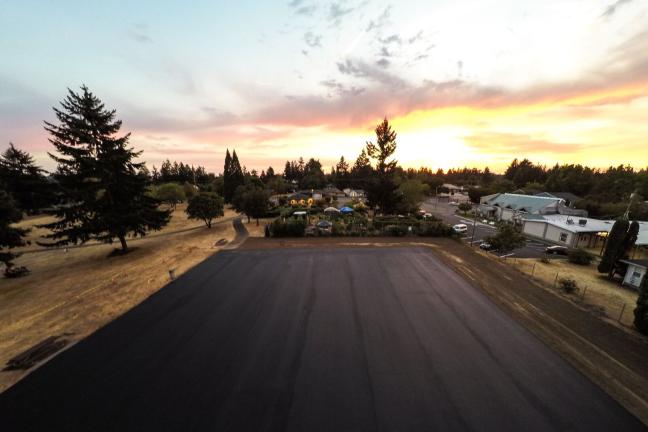 Freshly poured asphalt of the soon-to-be Snake Court glistens at sunset. Photo by Craig Gruenewald.