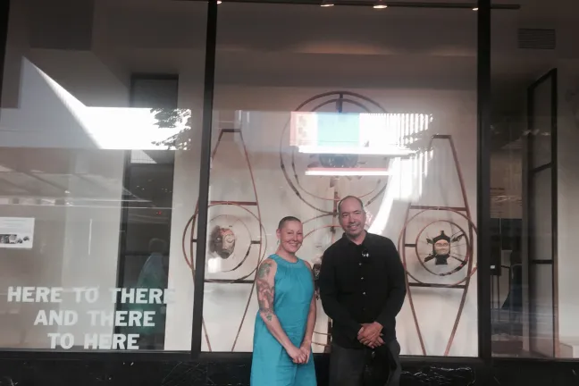 Terresa and Sean pose in front of their art at the Mead Building.