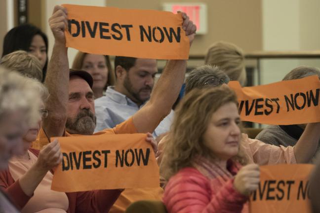 Activist show their support of the board's decision to divest in fossil fuel companies.