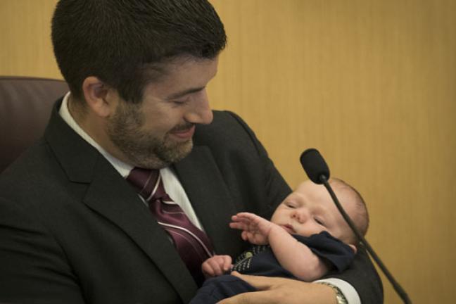 Commissioner Jules Bailey admires his two-week old son, August at Thursday's board meeting 