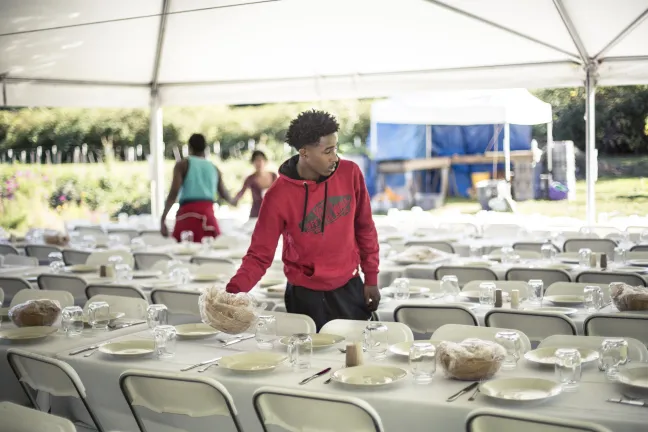 A participant in JSD programming sets up tables for the event. 