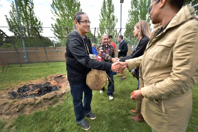 Latino Network care manager Rodolfo Serna and corrections technician Keyunna Baker greet each other during the blessing ceremony.