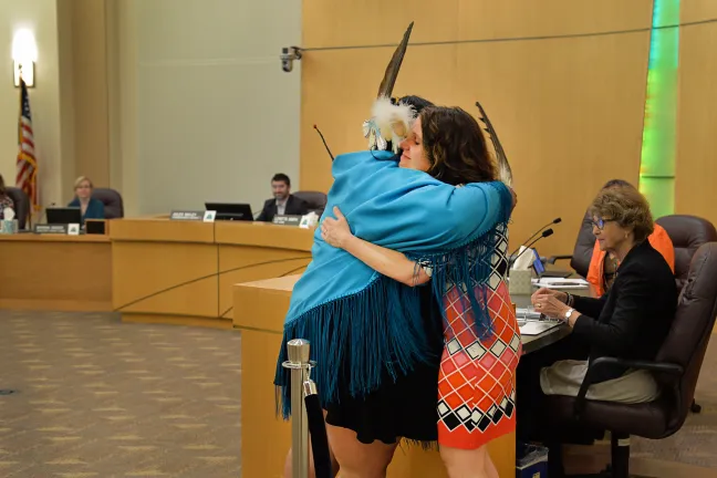 Candi Brings Plenty shares an embrace with Chair Deborah Kafoury at Thursday's board meeting.