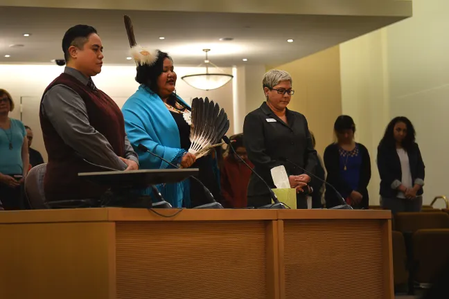 Director of the Equi Institute and the Portland Two Spirit Society Candi Brings Plenty (center) leads the board room in prayer at Thursday's meeting. She is joined by Manumalo Alailima (left) and Liz Rodriguez (right).