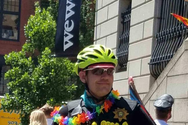 A Parole/Probation Officer (PPO) with Adult Services Division poses with his bike in the 2016 Pride Parade. 