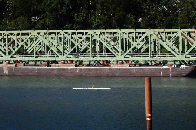 Spans from the old Sellwood Bridge sit on barges before delivery to a recycler.