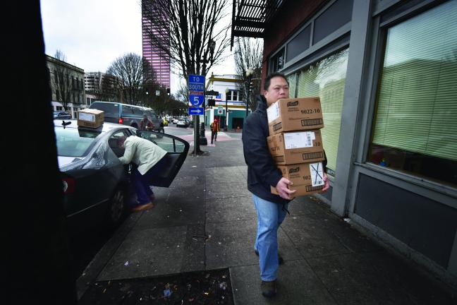 Uei Li, Emergency Preparedness and Response Manager for the Health Department, carries hand sanitizers to distribute to local shelters during the outbreak.