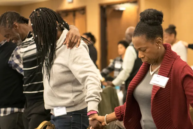 Denise Johnson with Care Oregon bows head for prayer.