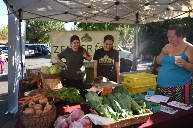 Angela Reed, right, samples veggies at the CSA Partnership Celebration