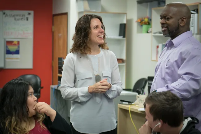 Chair Deborah Kafoury jokes with staff in study hall at Rosemary Anderson High School