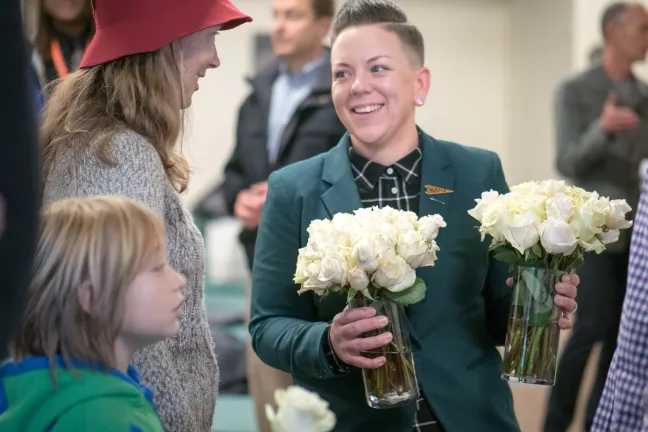 Stacy Borke of Transition Projects accepts donated roses for the opening.