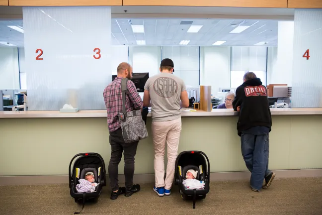 Ben and Jonas Rosenberg at customer service with their two-week-old twins Eva, left and Teddy.