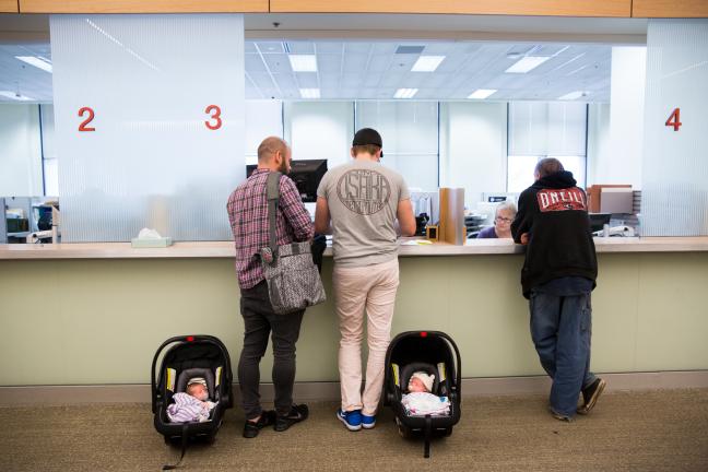 Ben and Jonas Rosenberg at customer service with their two-week-old twins Eva, left and Teddy.