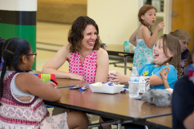 Chair Deborah Kafoury laughs with children enjoying a summer meal at Parkrose High.