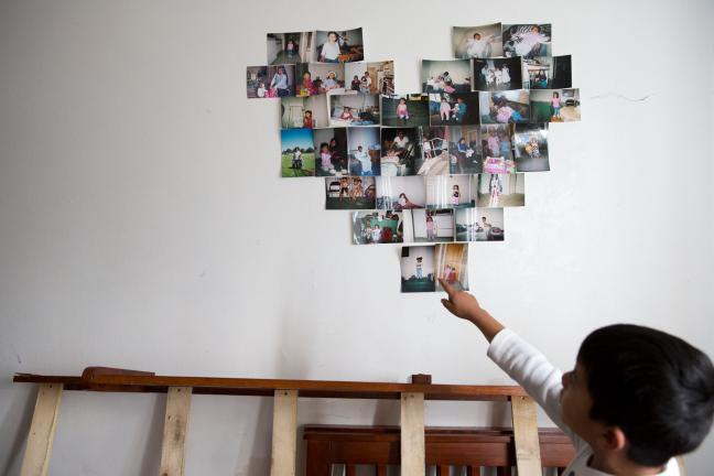 Adelfa's son Jorge Jr. shows off family photos before they're packed up for the move.