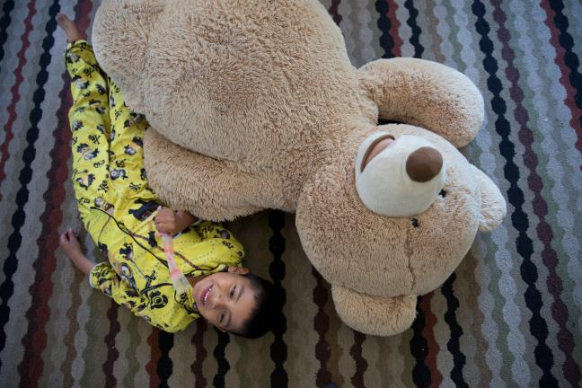 Jorge Jr. takes a break from wrestling with Teddy in his new living room.