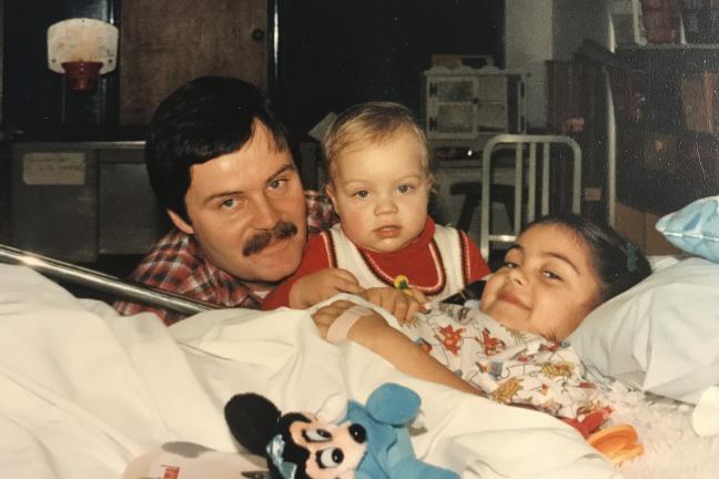 Daniela Schlechter-Keenan smiles from her hospital bed at Shriners Hospitals for Children, next her her little brother Arturo and her father William.