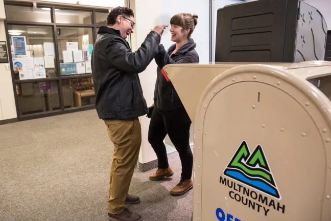 Laurielle Aviles (left) cast her ballot at the Voting Center Express on Tuesday. Her partner, Leah Middleton, joined her for “moral support.”