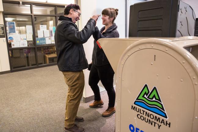 Laurielle Aviles (left) cast her ballot at the Voting Center Express on Tuesday.  Her partner, Leah Middleton, joined her for “moral support.”