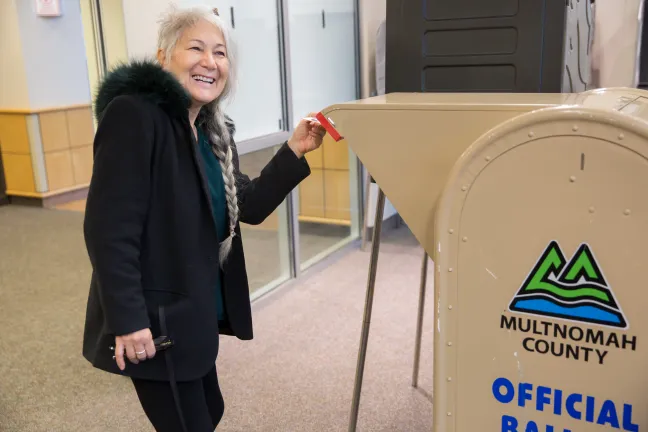 Yoga Instructor Myra Fleming drops off ballot at the Voting Center Express in Greshasm after teaching a yoga class at the Multnomah County East Building.