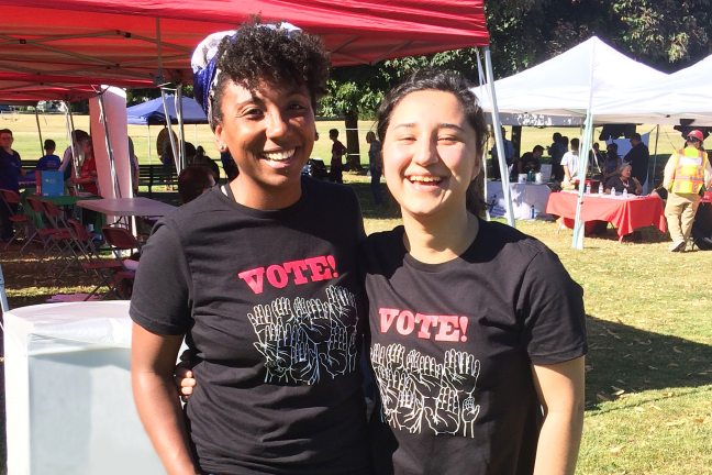 Two young girls laughing and smiling at an event