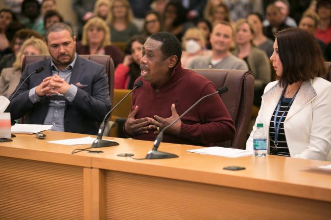 Clinical health specialist and Employees of Color ERG member Larry Turner (center) addresses the board as Chief Diversity and Equity Officer Ben Duncan (left) and Immigrants and Refugees ERG Chair Victoria Cross (right) look on.