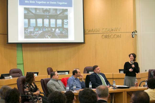 Sherrie Pelsma from the Community Energy Project gives her presentation to the audience while her fellow presenters look on.