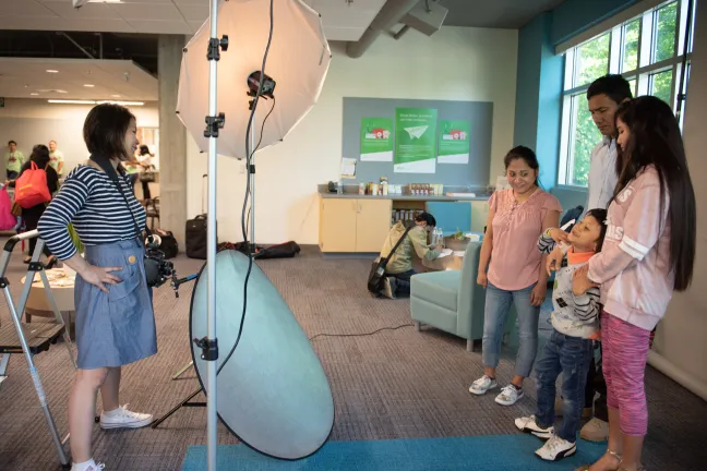 Photographer Kim Nguyen takes professional portraits at Refugee Adjustment Day 2018