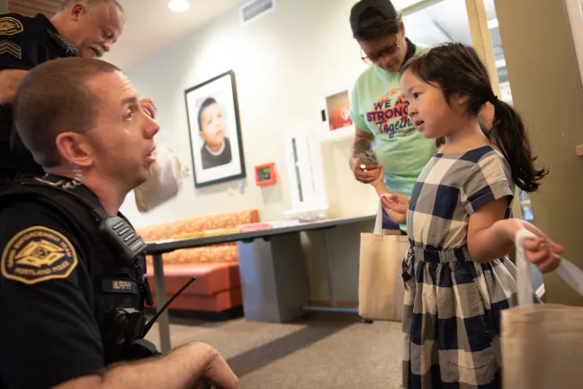 Portland Police Officer Patrick Murphy hands out stickers at Refugee Adjustment Day 2018