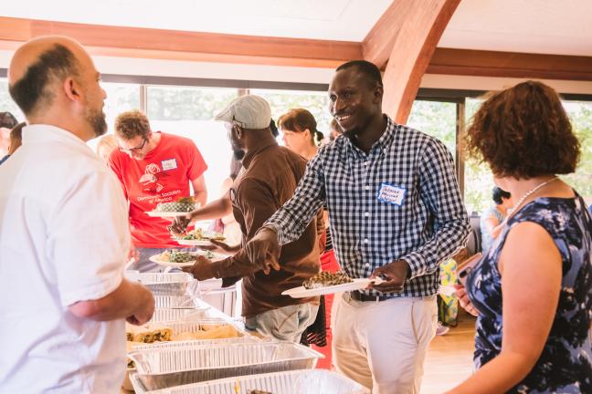 Thomas Aquinas Debpuur, (center) who works for IRCO’s Africa House, shares a meal with other forum participants.