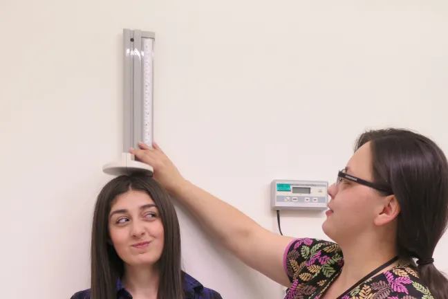 A student at Centennial's Student Health Center stops for a height check