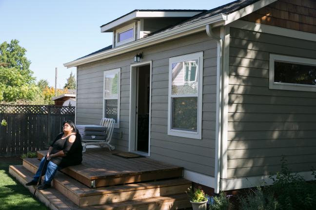 Sherry sits on the steps of her new home