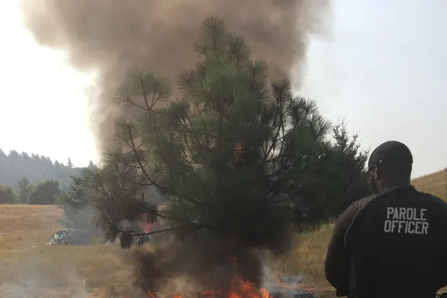 Alex C. Jones, mental health parole and probation officer, helps put out flames of Southeast Portland fire.