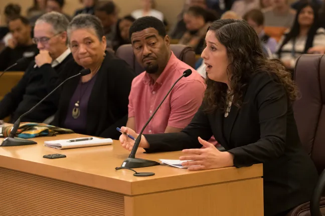 Chief Operating Officer Marissa Madrigal (right) address the board as Kory Murphy, member of the Safety, Trust and Belonging Advisory Council and equity and inclusion manager for the Department of County Assets looks on.