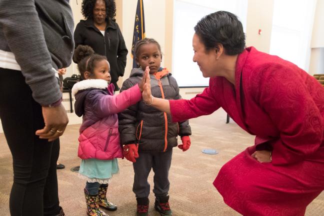 Commissioner Stegmann high fives the great-grandchildren of Gladys McCoy, Jazraia and Solomon.