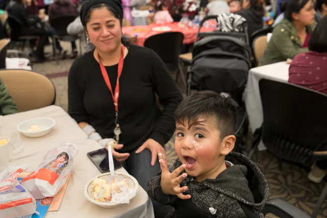 Sesai Ruano, 3, shows off his cake-covered hand as his mom Maria, looks on.