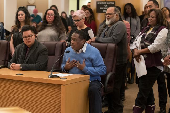 Health Department employee Larry Turner addresses the board Thursday surrounded by fellow members of the Multnomah County Employees of Color Employee Resource Group.