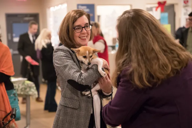 Gov. Kate Brown holds Twix while the dog's mom, Jessica, looks on.