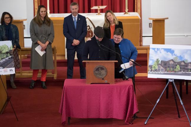 Pastor Elizabeth Larsen of St. Mark's Lutheran Church comforts Chris Aiosa, executive director of Do Good Multnomah, during an emotional moment in his remarks.