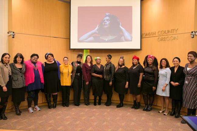 The Board of Commissioners poses with community members featured in the Albina Queens photo exhibition.