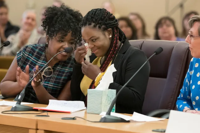 Tierra Howard, center, dabs her eyes as Mental Health and Addictions Services Director Ebony Clarke offers words of encouragement.