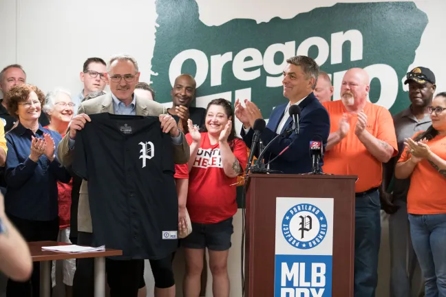 Craig Cheek of the Portland Baseball Diamond Project presents a prospective jersey to Tom Chamberlain, head of Oregon AFL-CIO.
