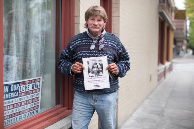 Kerry hold sup a memorial poster of his friend Andy, who passed away in 2018