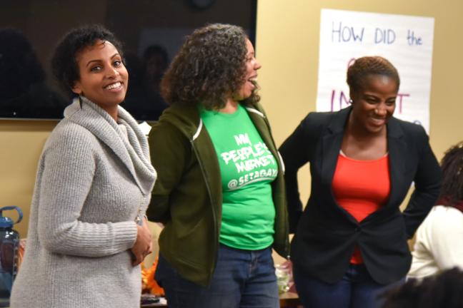 REACH Nutrition Specialist Helen Kidane, left, jokes with farmer Shantae Jonson and REACH program manager Charlene McGee